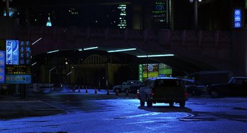 Movie still from “Mystery Men” (1999), directed by Kinka Usher – Cars are parked on the side of the road at night; Extreme Wide shot, High angle
