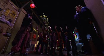 Movie still from “Mystery Men” (1999), directed by Kinka Usher – A group of people standing on a street at night; Wide shot, Low angle