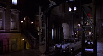 Movie still from “Mystery Men” (1999), directed by Kinka Usher – A car parked on the side of the street at night; Extreme Wide shot, High angle