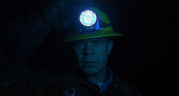 Movie still from “Mystery Men” (1999), directed by Kinka Usher – A man wearing a hard hat with a light on it; Close Up shot, Low angle
