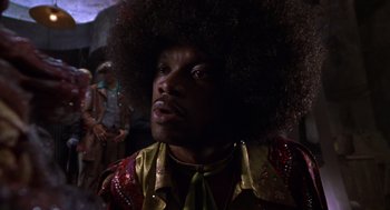 Movie still from “Mystery Men” (1999), directed by Kinka Usher – A man with a large afro is looking into the camera; Close Up shot, Low angle