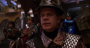 Movie still from “Mystery Men” (1999), directed by Kinka Usher – A man wearing a helmet and a suit of armor; Close Up shot, Low angle