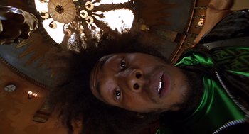 Movie still from “Mystery Men” (1999), directed by Kinka Usher – A person's face with an umbrella in the background; Extreme Close Up shot, Overhead angle