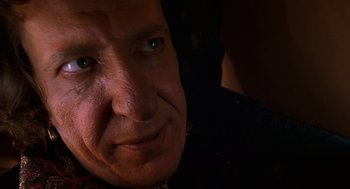 Movie still from “Mystery Men” (1999), directed by Kinka Usher – An older man with a serious look on his face; Close Up shot, Over the shoulder angle