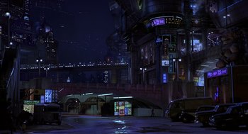 Movie still from “Mystery Men” (1999), directed by Kinka Usher – A night scene of a city street with a building in the background; Extreme Wide shot, High angle