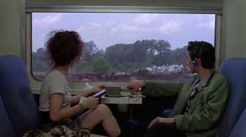 Movie still from “Mystery Train” (1989), directed by Jim Jarmusch – Two people sitting on a train looking out the window; Wide shot, Over the shoulder angle