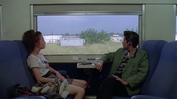 Movie still from “Mystery Train” (1989), directed by Jim Jarmusch – A man and a woman are sitting on a train; Medium shot, Over the shoulder angle
