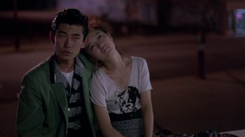 Movie still from “Mystery Train” (1989), directed by Jim Jarmusch – A man and a woman sitting next to each other; Medium shot, Over the shoulder angle