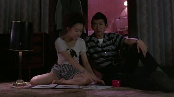 Movie still from “Mystery Train” (1989), directed by Jim Jarmusch – A man and a woman sitting on the floor; Medium shot, High angle