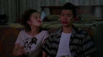 Movie still from “Mystery Train” (1989), directed by Jim Jarmusch – A young man sitting next to a young woman; Medium shot, Low angle