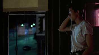 Movie still from “Mystery Train” (1989), directed by Jim Jarmusch – A man standing in front of a window at night; Medium shot, Over the shoulder angle
