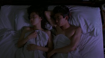 Movie still from “Mystery Train” (1989), directed by Jim Jarmusch – A man and a woman sleeping in a bed together; Medium shot, Overhead angle