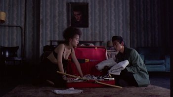 Movie still from “Mystery Train” (1989), directed by Jim Jarmusch – A woman sitting on the ground next to a man; Wide shot, High angle