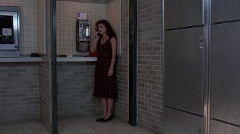 Movie still from “Mystery Train” (1989), directed by Jim Jarmusch – A woman standing in front of a phone booth talking on the phone; Wide shot, High angle