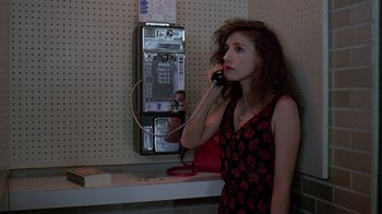 Movie still from “Mystery Train” (1989), directed by Jim Jarmusch – A woman talking on a phone next to a pay phone; Close Up shot, High angle