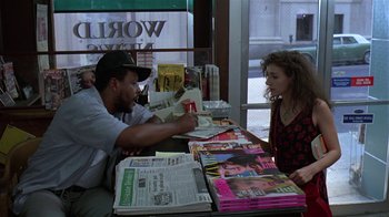 Movie still from “Mystery Train” (1989), directed by Jim Jarmusch – A man and a woman sitting at a table with magazines; Medium shot, Over the shoulder angle