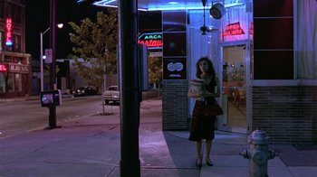 Movie still from “Mystery Train” (1989), directed by Jim Jarmusch – A woman standing on the side of the street at night; Wide shot, Low angle
