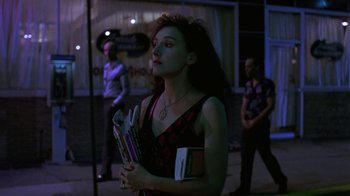 Movie still from “Mystery Train” (1989), directed by Jim Jarmusch – A woman holding a bunch of books in her hands; Medium shot, Low angle