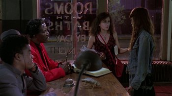 Movie still from “Mystery Train” (1989), directed by Jim Jarmusch – A group of people sitting around a table; Medium shot, Over the shoulder angle