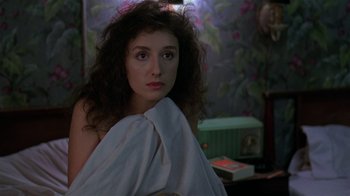 Movie still from “Mystery Train” (1989), directed by Jim Jarmusch – A young woman wrapped in a blanket in a room; Close Up shot, Over the shoulder angle