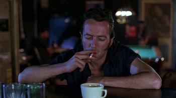 Movie still from “Mystery Train” (1989), directed by Jim Jarmusch – A man sitting in front of a cup of coffee; Close Up shot, Over the shoulder angle