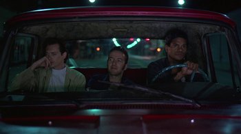 Movie still from “Mystery Train” (1989), directed by Jim Jarmusch – A group of men riding in a car at night; Medium shot, Low angle