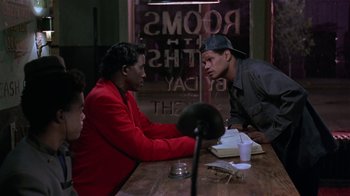 Movie still from “Mystery Train” (1989), directed by Jim Jarmusch – A group of men sitting at a table talking to each other; Medium shot, Over the shoulder angle
