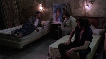Movie still from “Mystery Train” (1989), directed by Jim Jarmusch – A group of people sitting on mattresses in a room; Wide shot, High angle