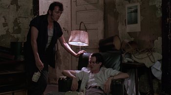 Movie still from “Mystery Train” (1989), directed by Jim Jarmusch – Two men are sitting in a living room; Medium shot, Low angle