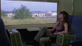 Movie still from “Mystery Train” (1989), directed by Jim Jarmusch – A woman sitting on a train looking out the window; Wide shot, High angle