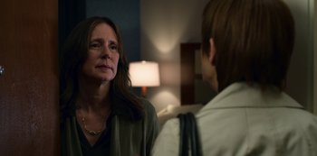 Movie still from “13 Reasons Why” (2017), created by Brian Yorkey – A woman standing next to another woman in front of a lamp; Close Up shot, Over the shoulder angle