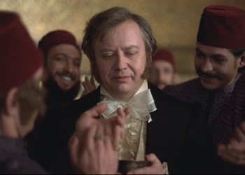 Movie still from “A Few Days from the Life of I.I. Oblomov” (1980), directed by Nikita Mikhalkov – A group of men standing next to each other in a room; Close Up shot, Over the shoulder angle