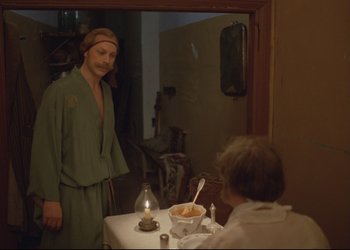 Movie still from “A Few Days from the Life of I.I. Oblomov” (1980), directed by Nikita Mikhalkov – A man standing in front of a table with a bowl of soup; Medium shot, Over the shoulder angle