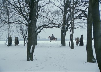 Movie still from “A Few Days from the Life of I.I. Oblomov” (1980), directed by Nikita Mikhalkov – A person on a horse in the snow near some trees; Extreme Wide shot, High angle