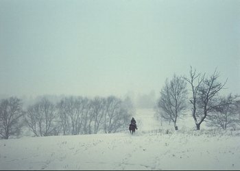 Movie still from “A Few Days from the Life of I.I. Oblomov” (1980), directed by Nikita Mikhalkov – A person riding a horse in a snowy field; Extreme Wide shot, High angle