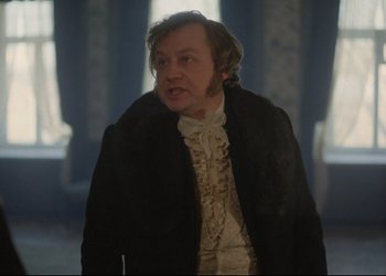 Movie still from “A Few Days from the Life of I.I. Oblomov” (1980), directed by Nikita Mikhalkov – A man wearing a black coat and a white shirt; Medium shot, Over the shoulder angle