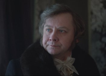 Movie still from “A Few Days from the Life of I.I. Oblomov” (1980), directed by Nikita Mikhalkov – An older man wearing a fur coat and a white bow tie; Close Up shot, Over the shoulder angle
