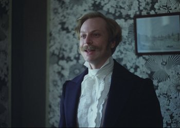 Movie still from “A Few Days from the Life of I.I. Oblomov” (1980), directed by Nikita Mikhalkov – A man in a suit with a mustache; Medium shot, Low angle