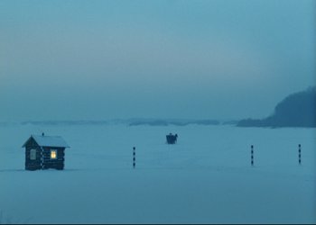 Movie still from “A Few Days from the Life of I.I. Oblomov” (1980), directed by Nikita Mikhalkov – A view of a snowy field at night with a light on; Extreme Wide shot, High angle