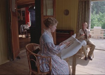 Movie still from “A Few Days from the Life of I.I. Oblomov” (1980), directed by Nikita Mikhalkov – A woman sitting in a chair looking at a sheet of paper; Wide shot, High angle