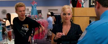 Movie still from “Observe and Report” (2009), directed by Jody Hill – A woman in black shirt holding a purse in a store; Medium shot, Over the shoulder angle