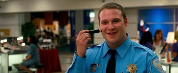 Movie still from “Observe and Report” (2009), directed by Jody Hill – A police officer holding up a cell phone to his ear; Close Up shot, High angle