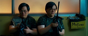 Movie still from “Observe and Report” (2009), directed by Jody Hill – Two men sitting next to each other holding a rifle; Medium shot, High angle