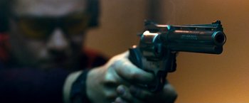 Movie still from “Observe and Report” (2009), directed by Jody Hill – A person is holding a gun in their hand; Extreme Close Up shot, Low angle