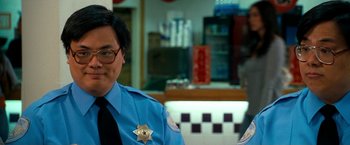 Movie still from “Observe and Report” (2009), directed by Jody Hill – A man in a police uniform sitting next to another man; Close Up shot, Over the shoulder angle