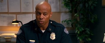 Movie still from “Observe and Report” (2009), directed by Jody Hill – A police officer in uniform is sitting in a room; Close Up shot, Over the shoulder angle