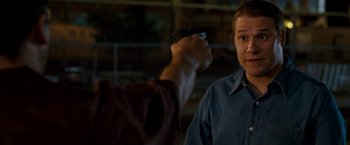 Movie still from “Observe and Report” (2009), directed by Jody Hill – A man holding a gun pointed at another man; Close Up shot, Over the shoulder angle
