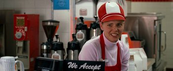 Movie still from “Observe and Report” (2009), directed by Jody Hill – A woman wearing a red and white hat smiles for the camera; Close Up shot, Over the shoulder angle