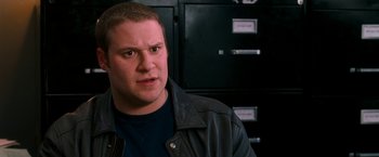 Movie still from “Observe and Report” (2009), directed by Jody Hill – A man wearing a leather jacket standing in front of some filing cabinets; Close Up shot, High angle