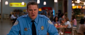 Movie still from “Observe and Report” (2009), directed by Jody Hill – A police officer in a blue uniform is looking angry; Close Up shot, Over the shoulder angle